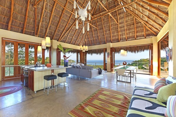 A spacious living area with a kitchen, a dining area, and a seating area with a view of the ocean. - 3 Bedroom, 4 Bath, 30 ft. Soaring Palapa, Spectacular Ocean Views, 40 foot pool (Sayulita)
