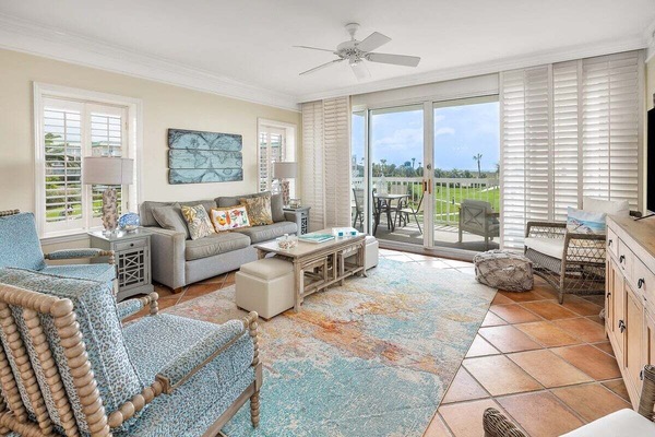 St. Simons Grand #102 living room with sofa, side chairs, and patio access