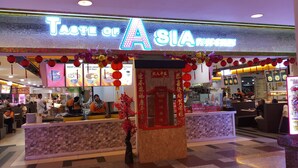 A restaurant named "Taste of Asia" with a neon sign, a brick counter, and red lantern decorations. - Residency Suites At Times Square (Kuala Lumpur)