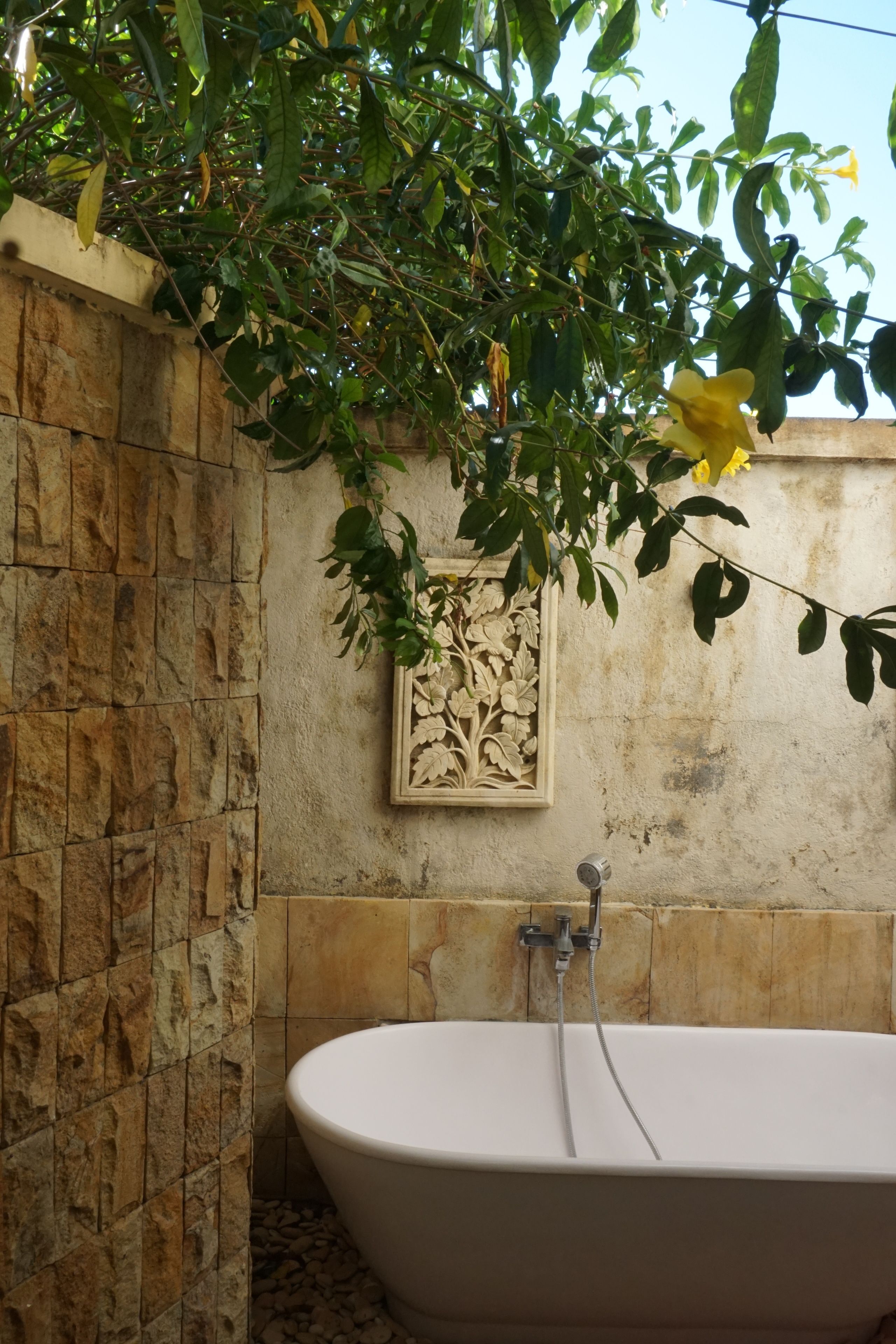 Ein Badezimmer mit einer Badewanne, einer Steinwand und einer Zierleiste.
