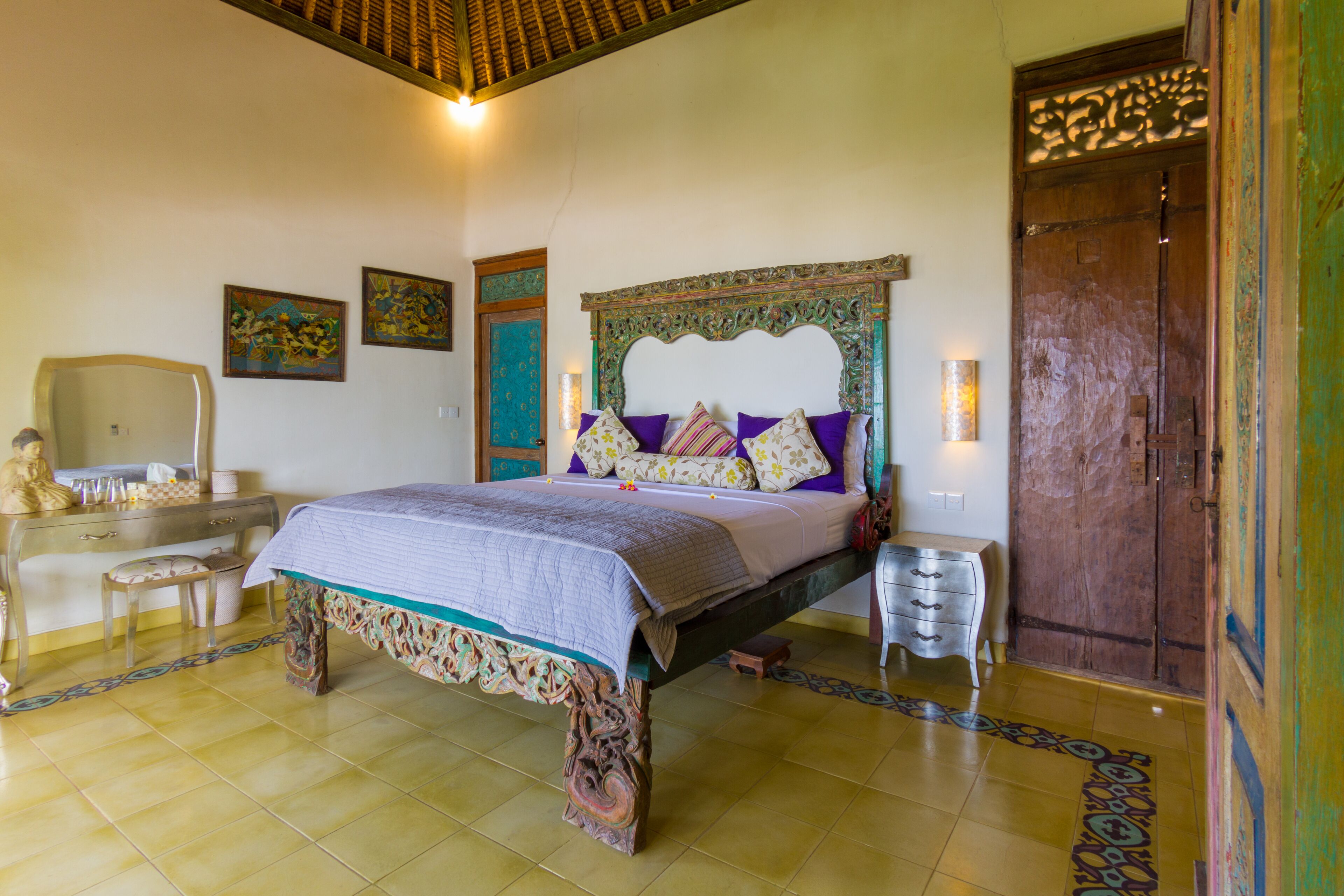 A traditional room with a bed, a dresser, and a mirror.