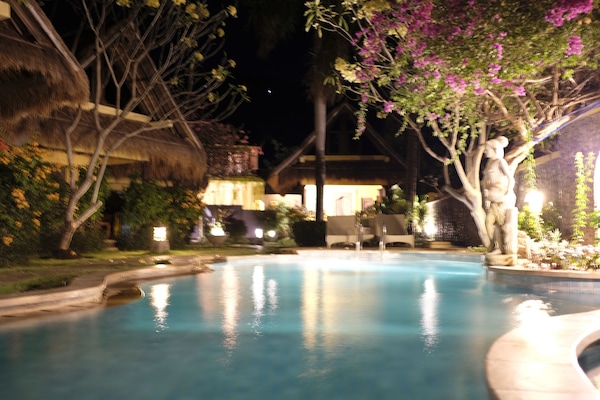 Una piscina al aire libre, sillones reclinables de piscina