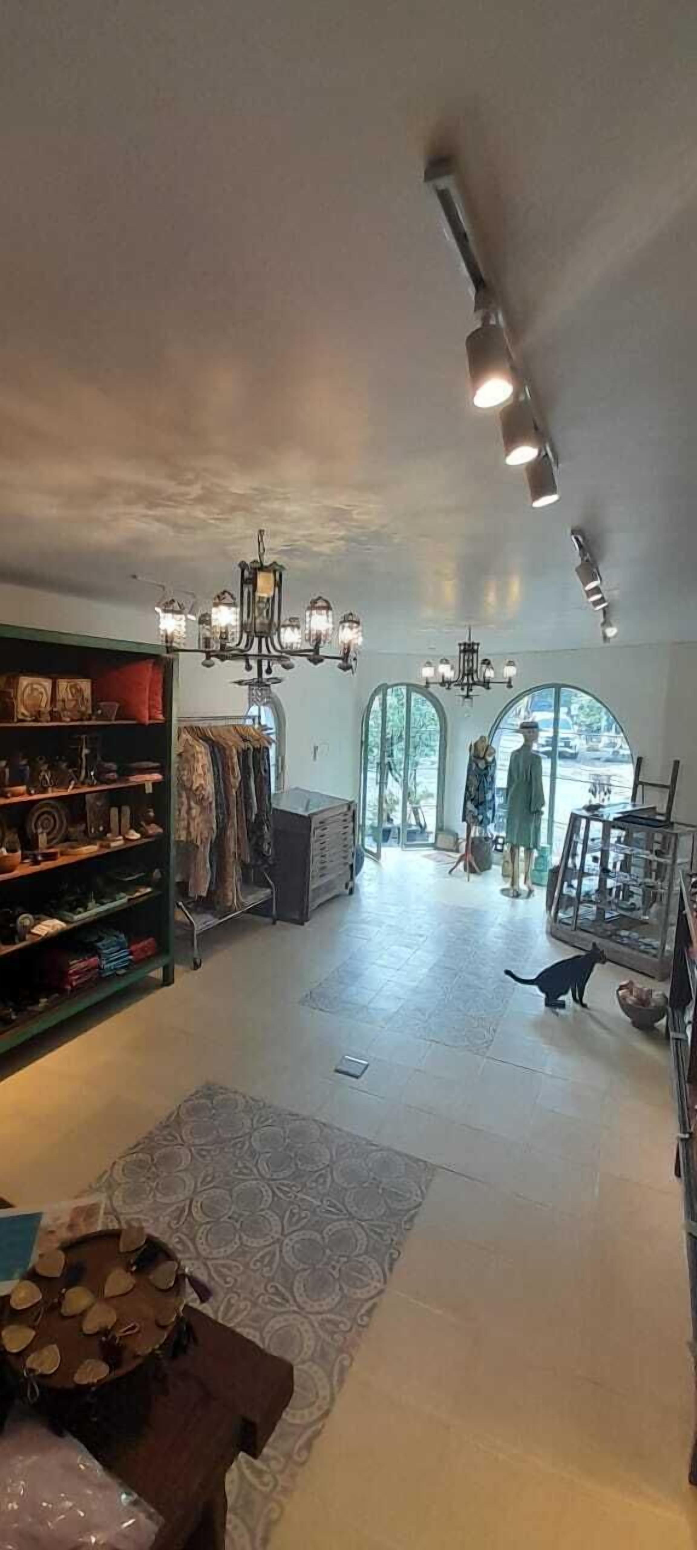 A spacious interior with a high ceiling, chandeliers, and a central walkway.