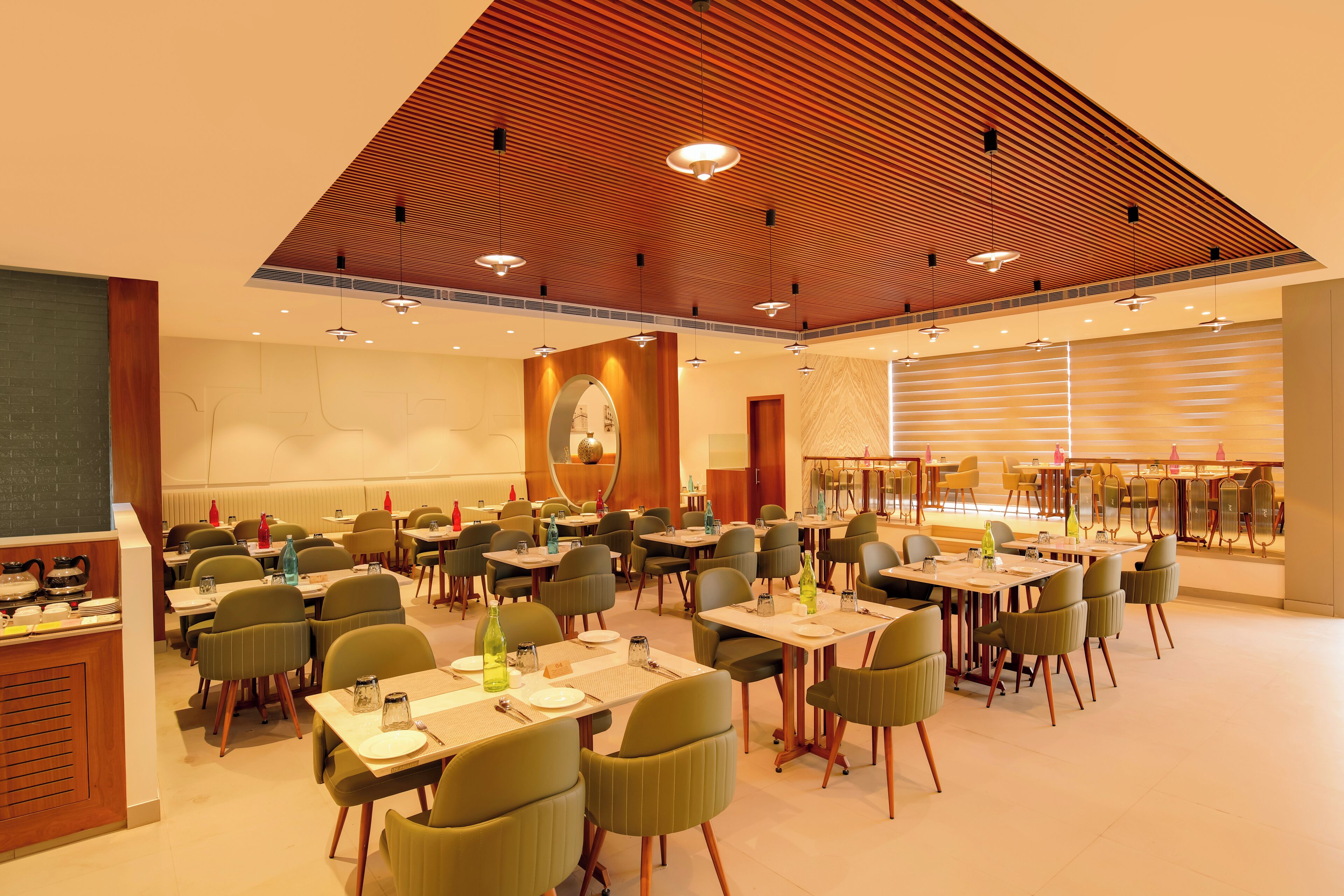 A spacious dining area with multiple tables and chairs, a wooden ceiling, and a bright, well-lit ambiance.