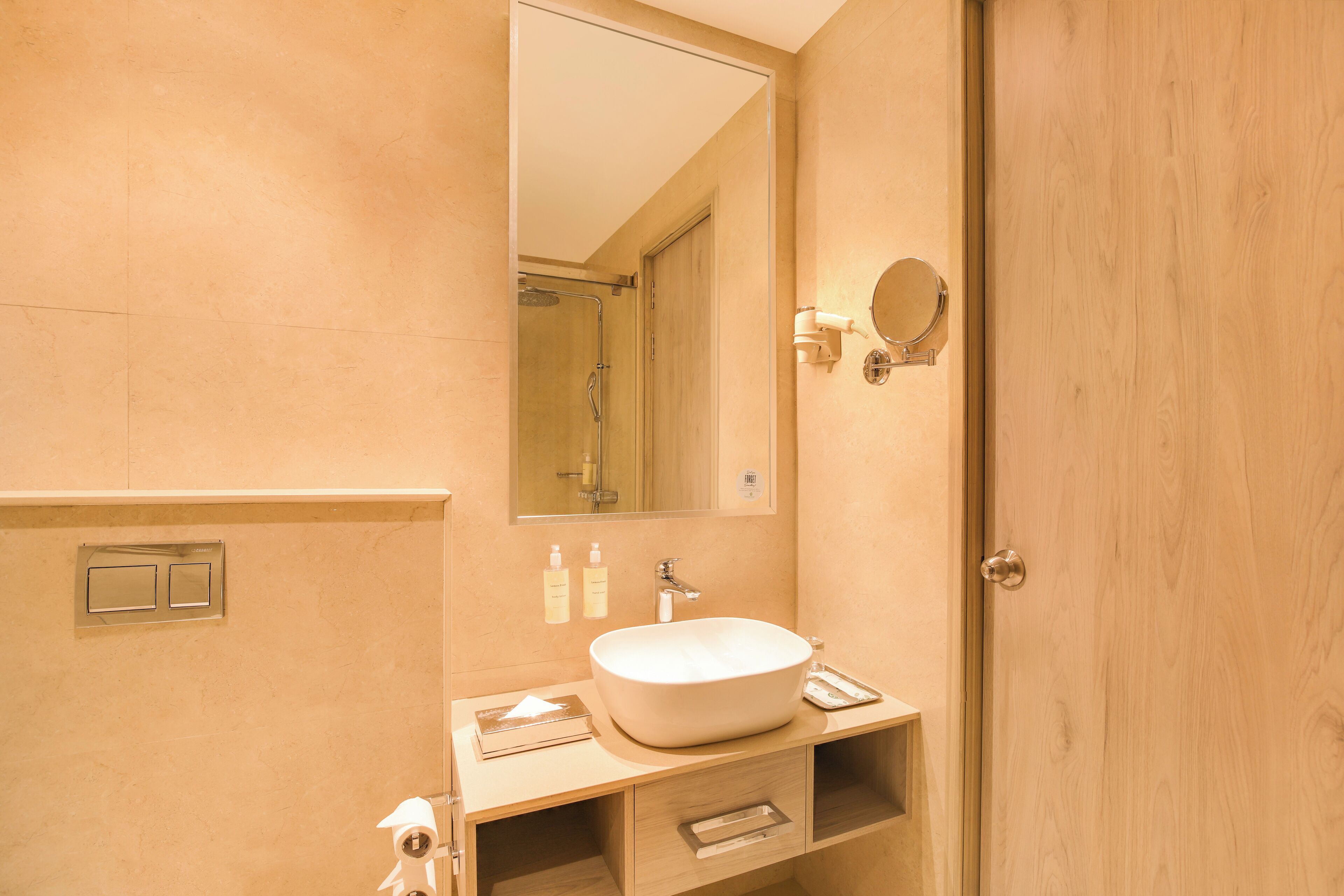 A bathroom with a large mirror, a sink, and a door.