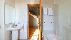 A modern bathroom with a sink, mirror, and glass shower enclosure.