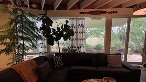Un salon moderne avec un canapé d’angle, une table basse et une grande plante.
