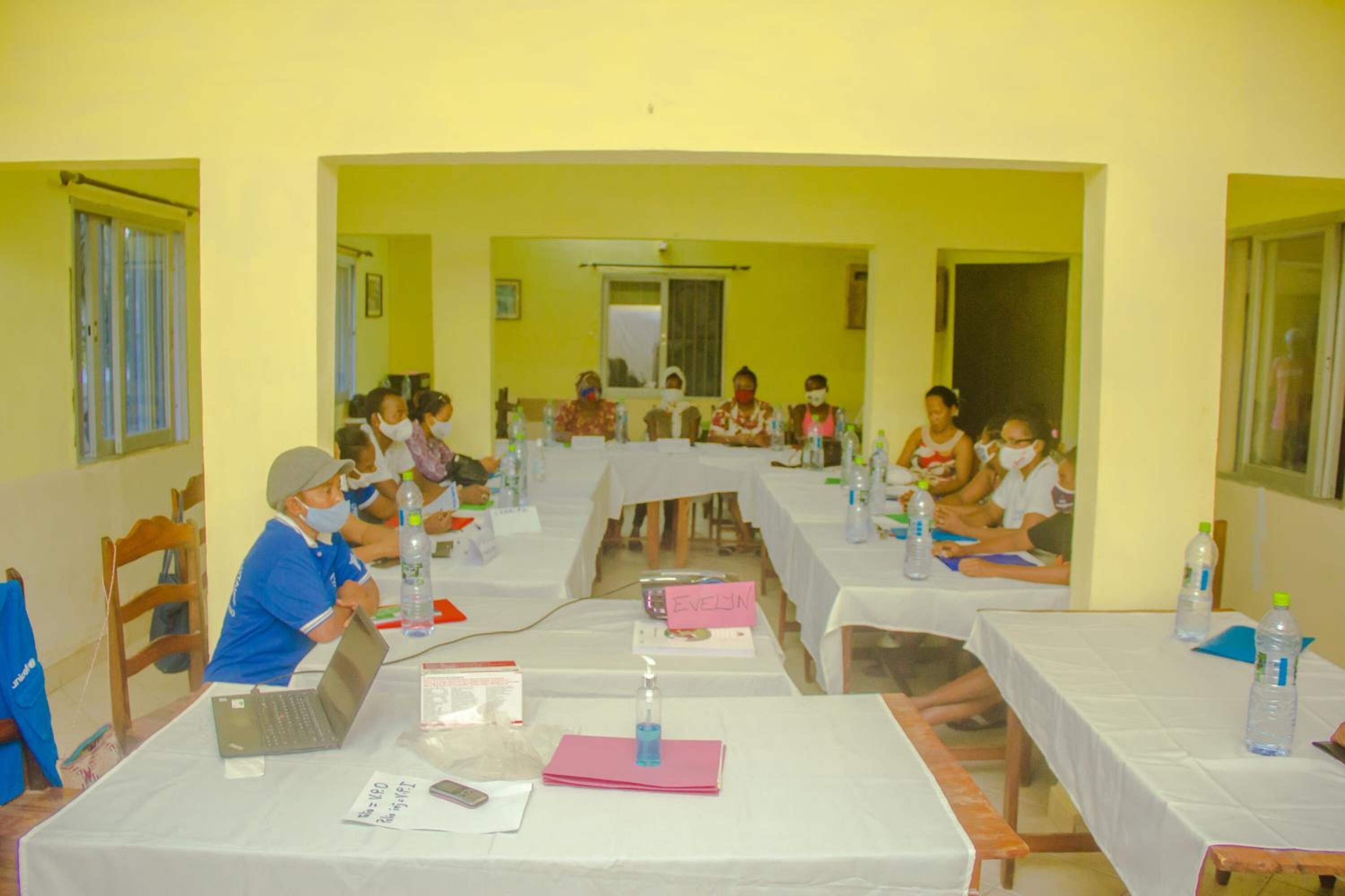 A conference room with long tables, laptops, and water bottles.