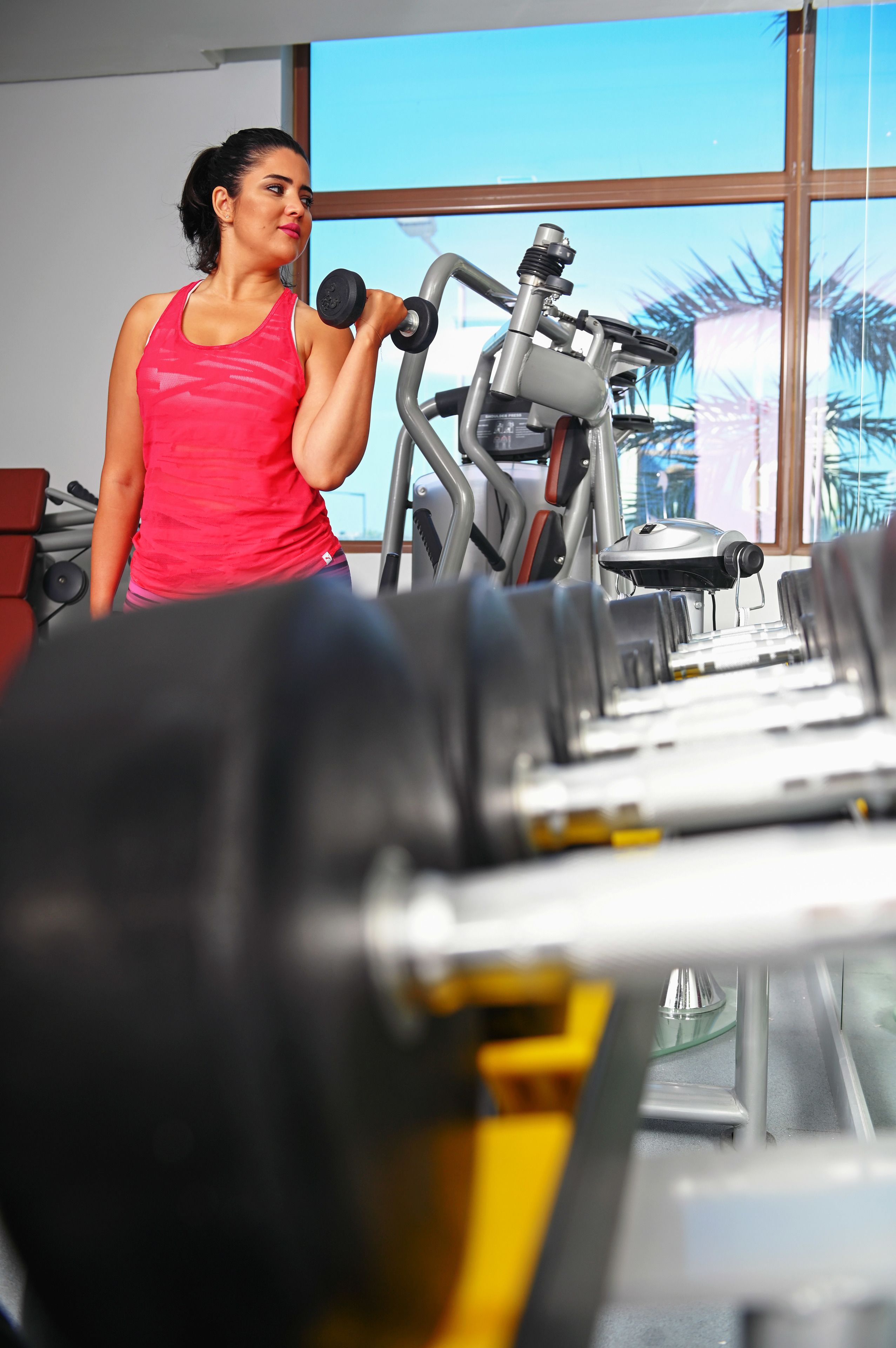 Une salle de sport équipée de matériel d’exercice, notamment des haltères et un tapis de course.