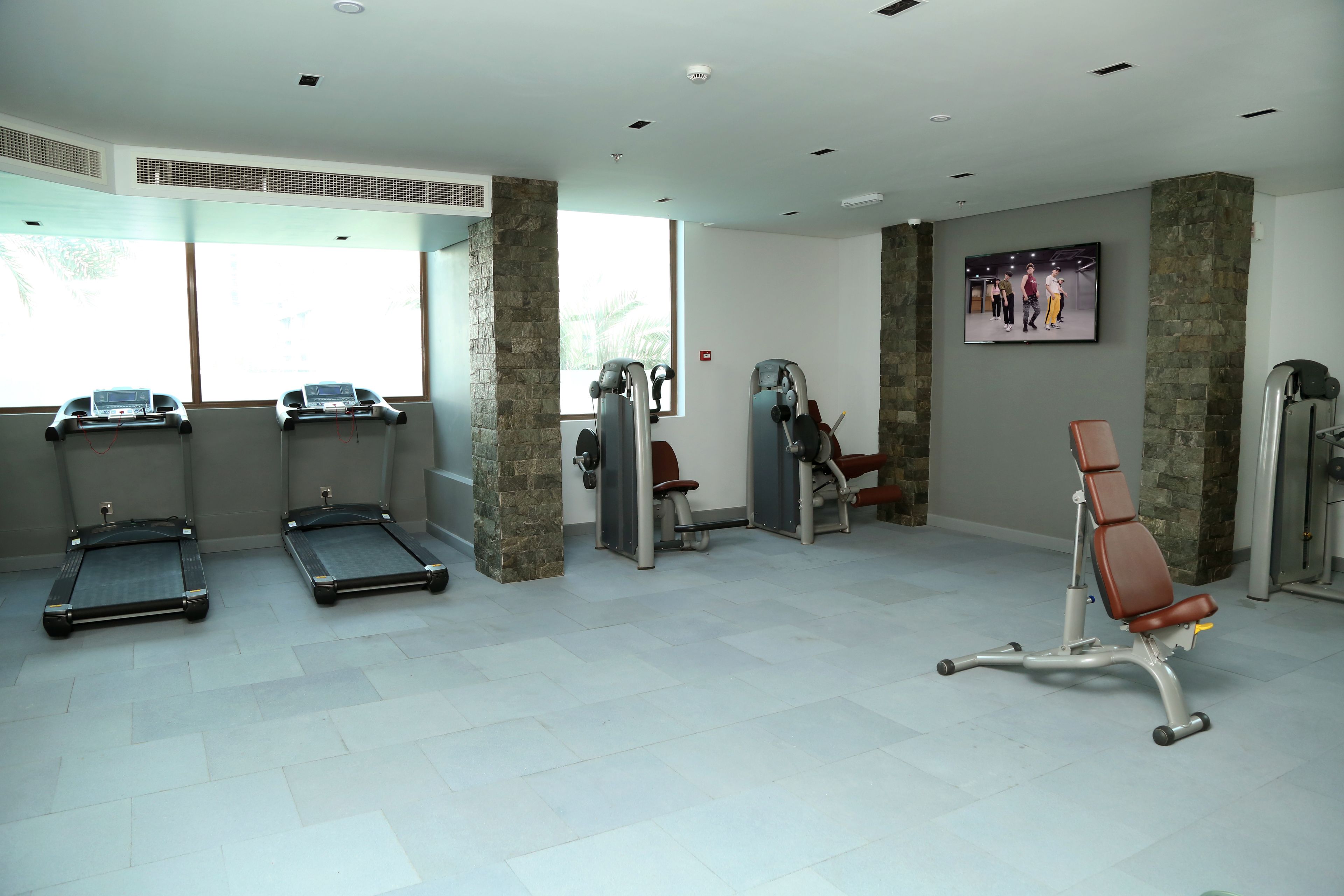 Un gimnasio con cintas de correr, máquinas de pesas y una bicicleta estática.