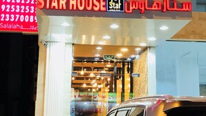 Een Star House gebouw met een bord waarop contactnummers en de naam 'Star House' staan.