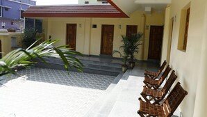 A building with a tiled entrance area, wooden doors, and a covered walkway. - Nest Guest House (Bhubaneshwar)