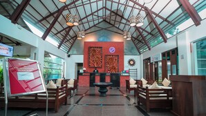A reception area with a high ceiling, wooden furniture, and a central decorative feature. - The Ocean Pearl Resort And Spa (Dharwad)