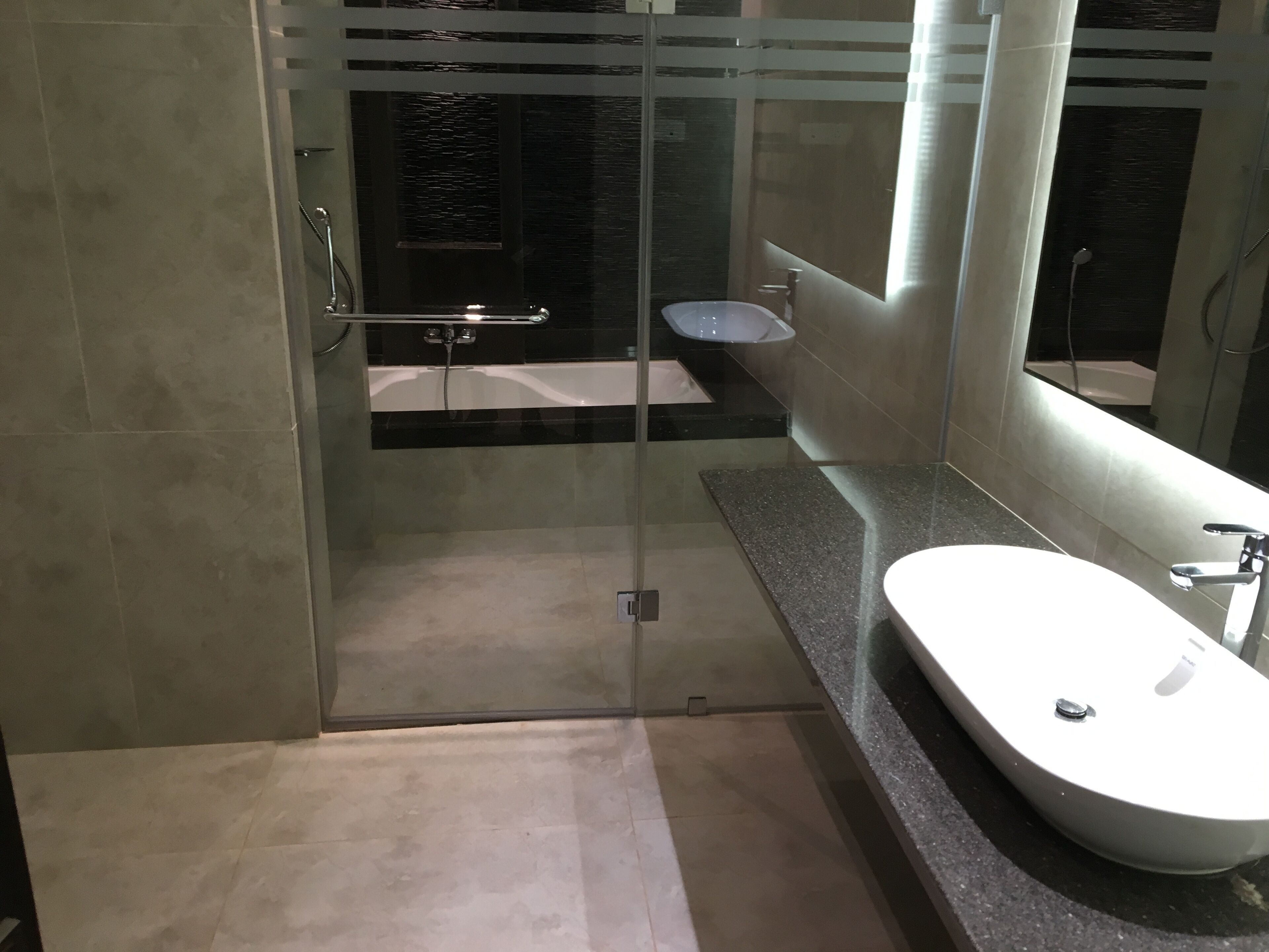Une salle de bain moderne avec une douche à parois de verre, une baignoire sur pieds et un lavabo indépendant.