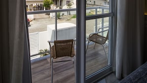 Un balcón con vista a una zona residencial, que incluye casas y un paisaje montañoso.
