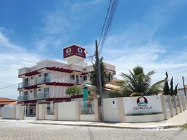 Un edificio de varios pisos con un letrero llamativo que dice "Pousada Espindola".