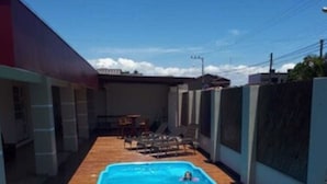 Una piscina rectangular rodeada por un deck de madera.