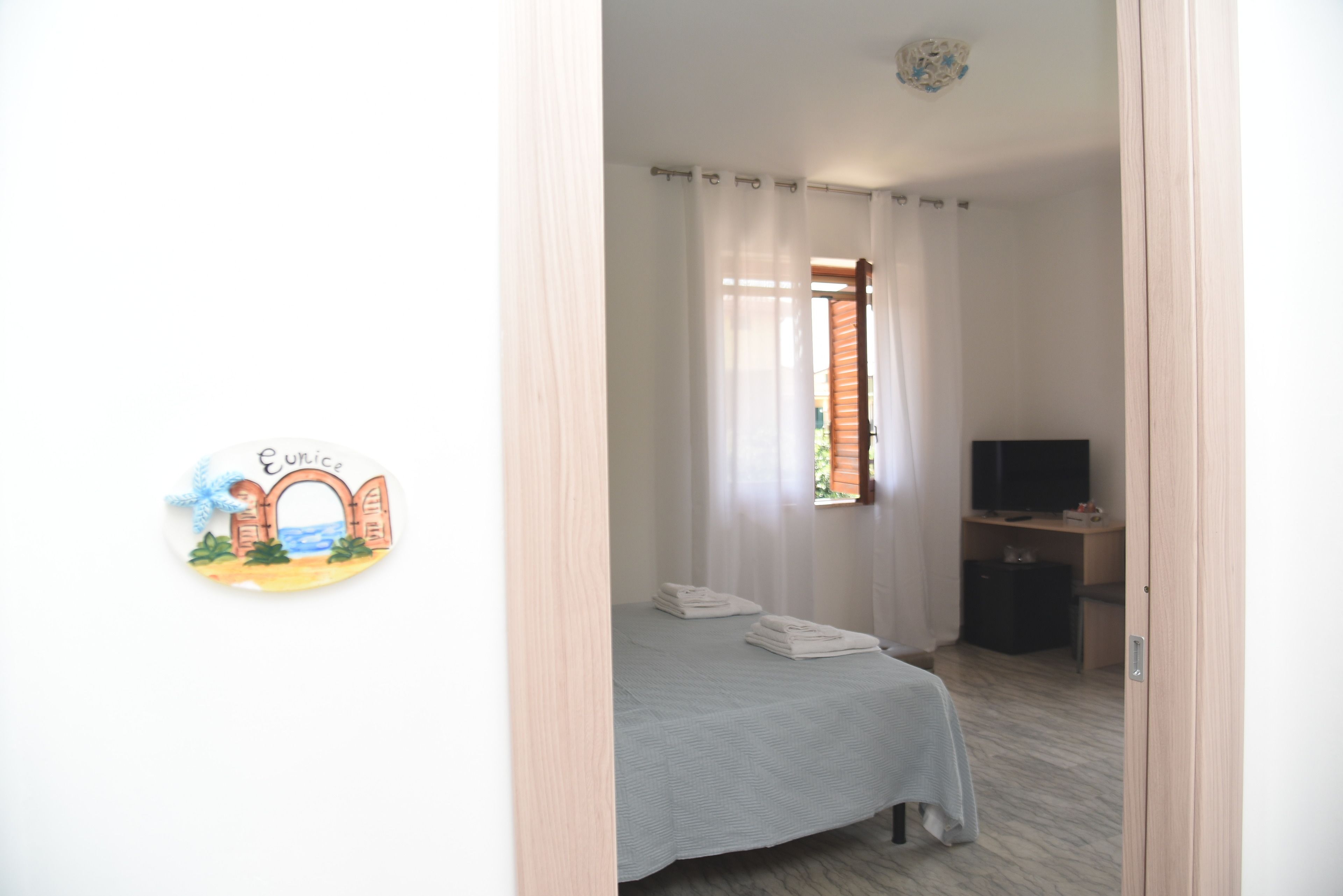 Une chambre à coucher avec un lit, une télévision et un bureau.
