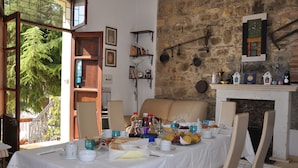 A dining area with a table set for breakfast, a stone wall, and a fireplace. - B & B La Panoramica (Villapiana)