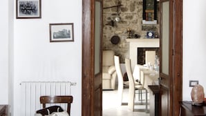 A hallway with a stone archway leading to a dining area with a table and chairs. - B & B La Panoramica (Villapiana)