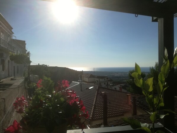 A balcony with a view of the sea and buildings in the distance. - B & B La Panoramica (Villapiana)
