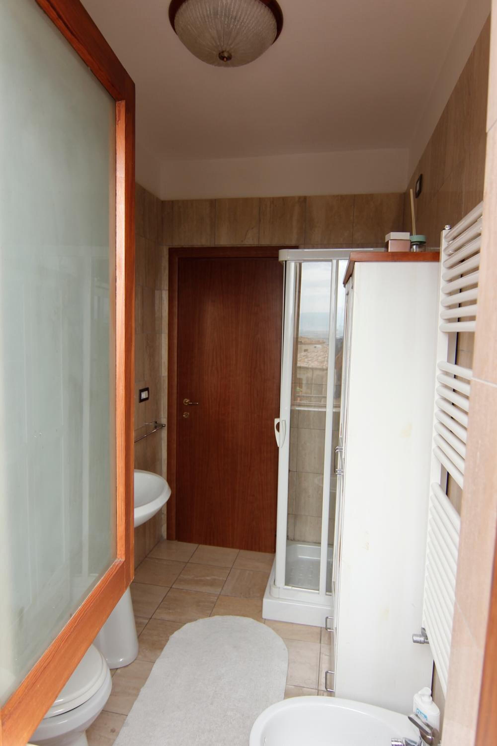 A compact bathroom with a toilet, sink, and shower.
