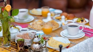 A breakfast table with various dishes, cups, and a teapot. - Riad Dar Leuleu (Marrakech)