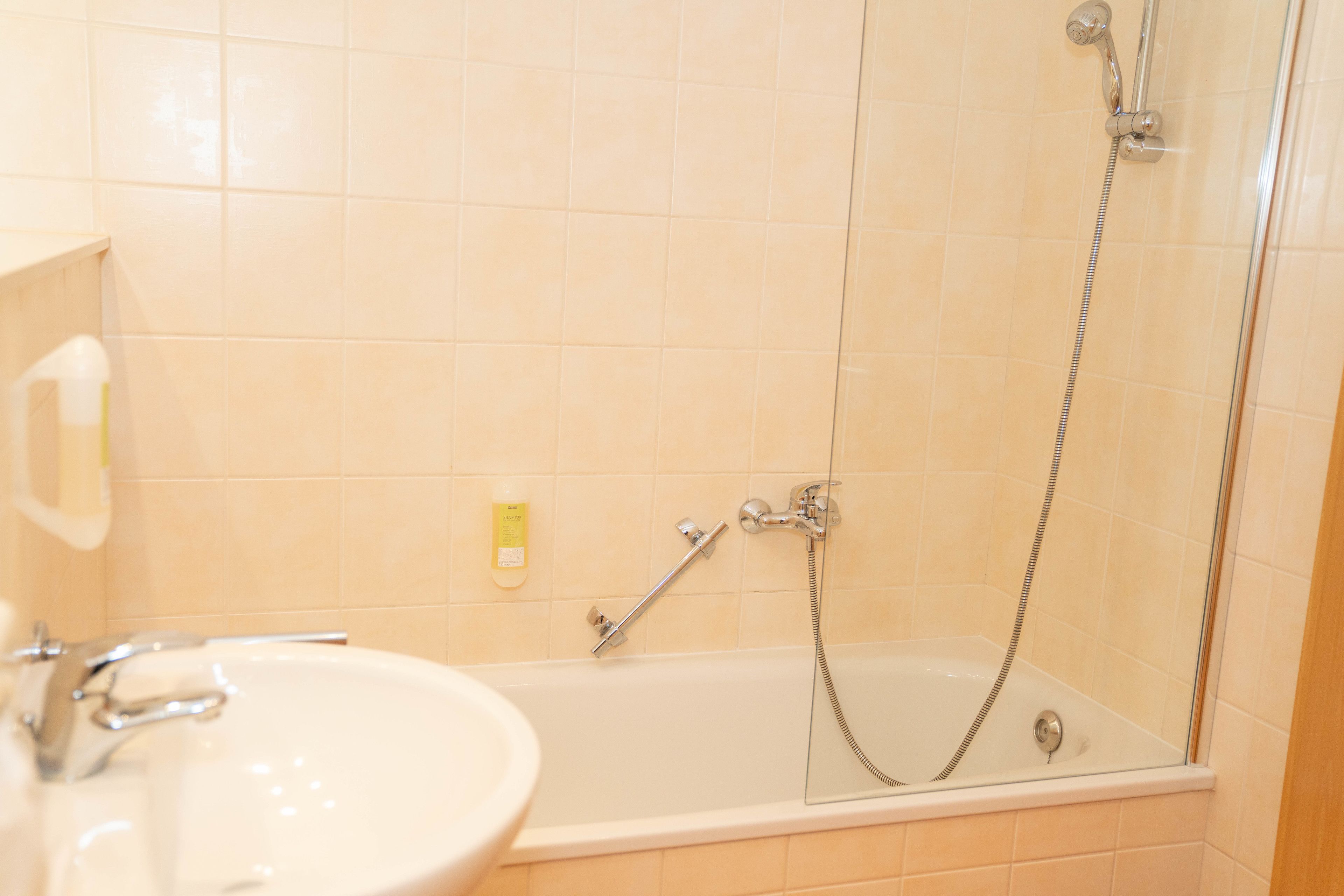 A bathroom with a bathtub, a shower, and a sink.