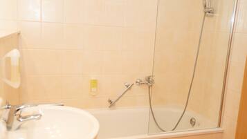 A bathroom with a bathtub, a shower, and a sink.