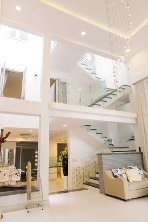 A spacious, multi-level living area with a staircase, a dining area, and a sofa. - Green House - 2 Deluxe room w/ 5 mins walk to Perfume River (Tp. Huế)