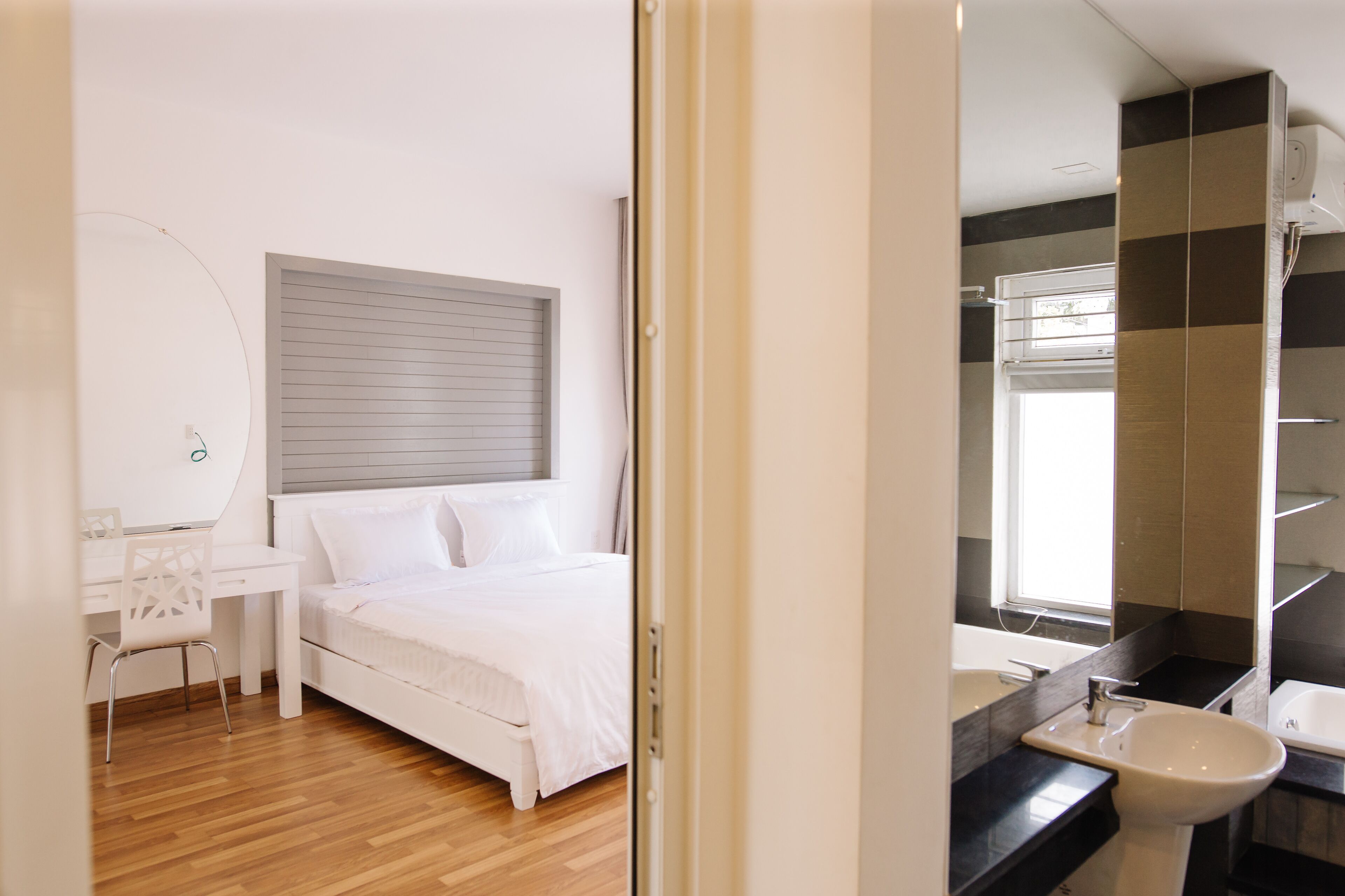 A bedroom with a bed, a desk, and a chair.