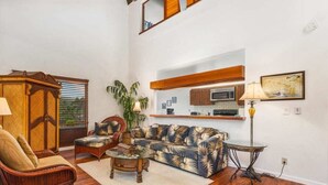 Una sala de estar con sofá, sillones, mesa de centro, aparador y lámpara.