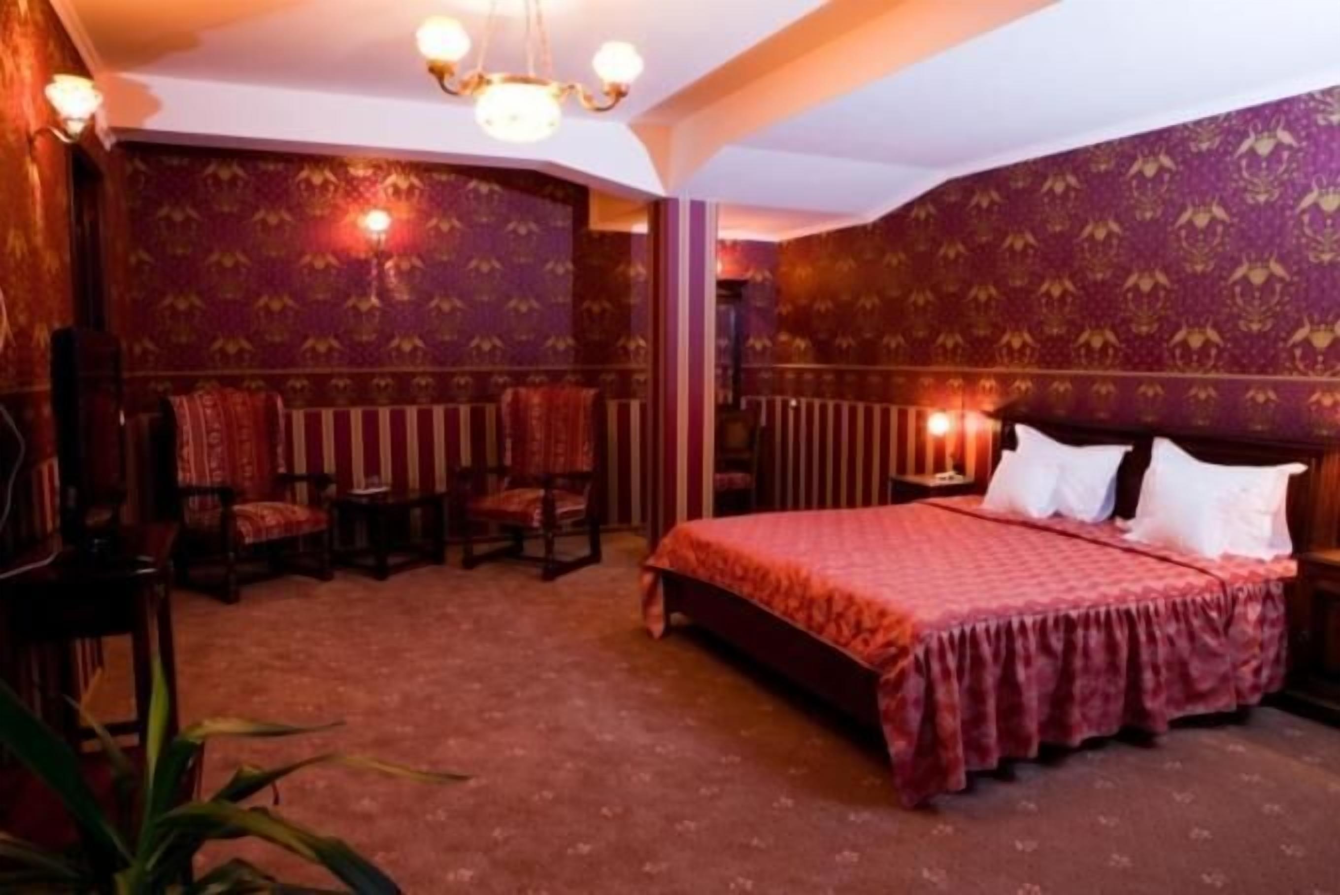 Una habitación con una cama grande, un radiador y varias sillas.