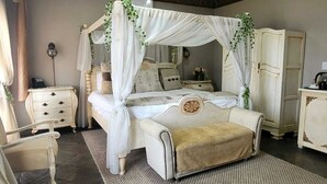 Une chambre à coucher avec un lit à baldaquin, une table de chevet, une commode et une chaise.