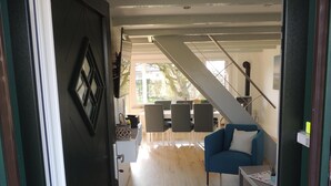 A modern living room with a staircase leading to a dining area.