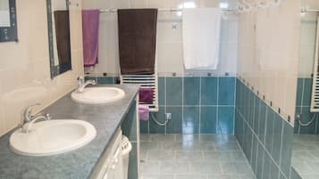 Une salle de bain avec deux lavabos, un miroir et un porte-serviettes.