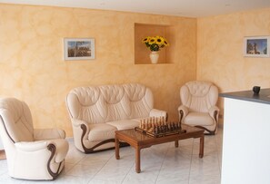 A living room with a beige sofa set, two armchairs, a coffee table, and a chessboard. - Homerez - House in Mouterre-Silly. (Mouterre-Silly)