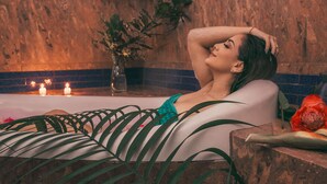 A woman relaxing in a bathtub with candles and plants around her. - Kashama Eco Resort y Spa (Valle Hermoso)