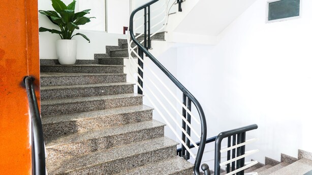 A staircase with granite steps and black railings, leading to a white door. - Hue Royal Hotel (Hue)