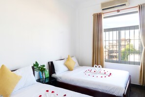 Habitación cuádruple Deluxe | Minibar, caja de seguridad en la habitación y escritorio 