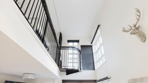 Et moderne interiør med balkon, store vinduer og et gevir.