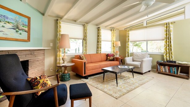 A living room with a fireplace, a sofa, a coffee table, and a bookshelf.