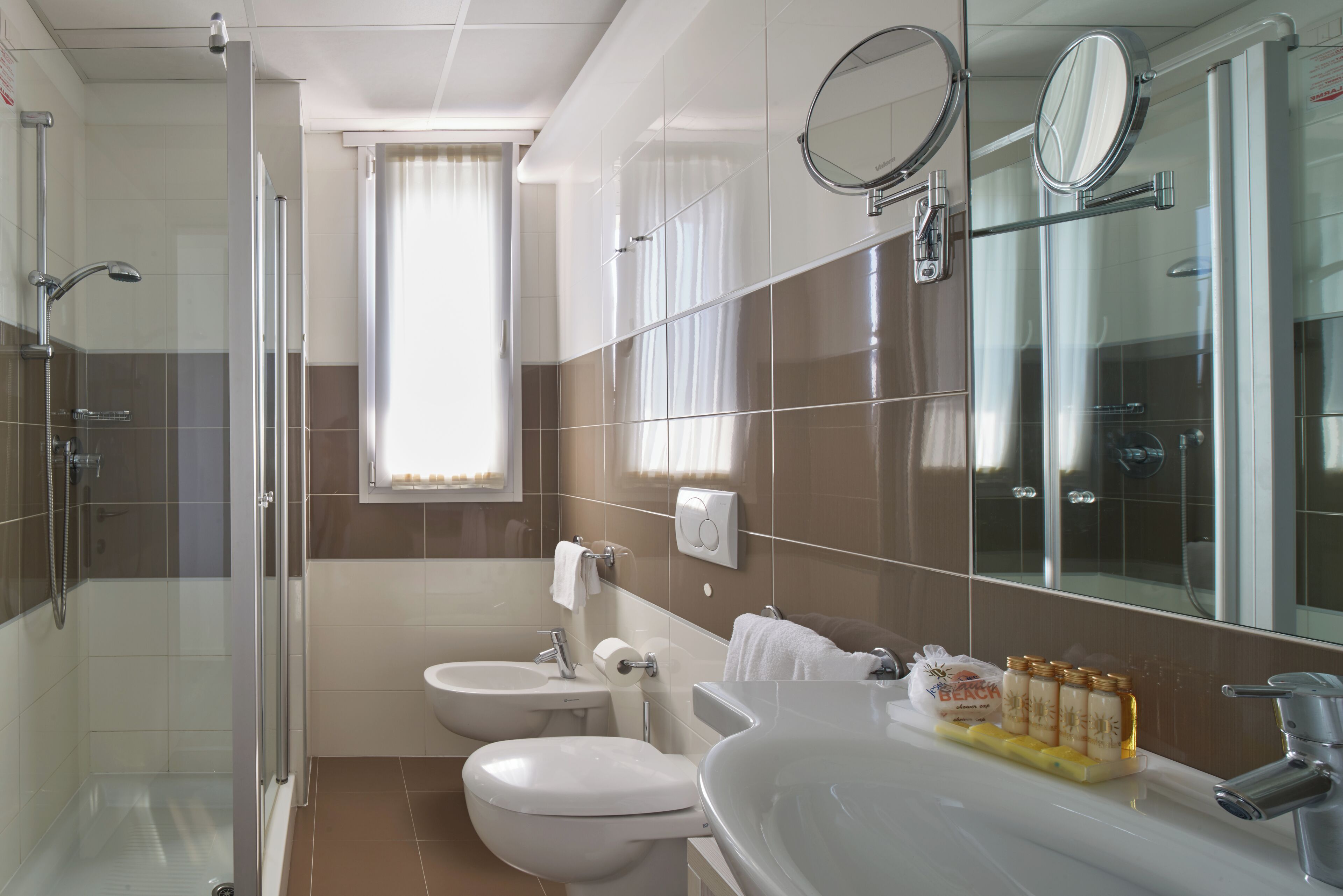 A modern bathroom with a glass shower enclosure, a sink, a toilet, and a vanity.