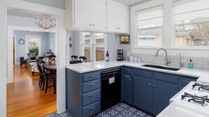 A kitchen with white cabinets, a blue countertop, and a gas stove.