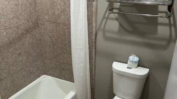 Une salle de bain avec une baignoire, des toilettes et un porte-serviettes.