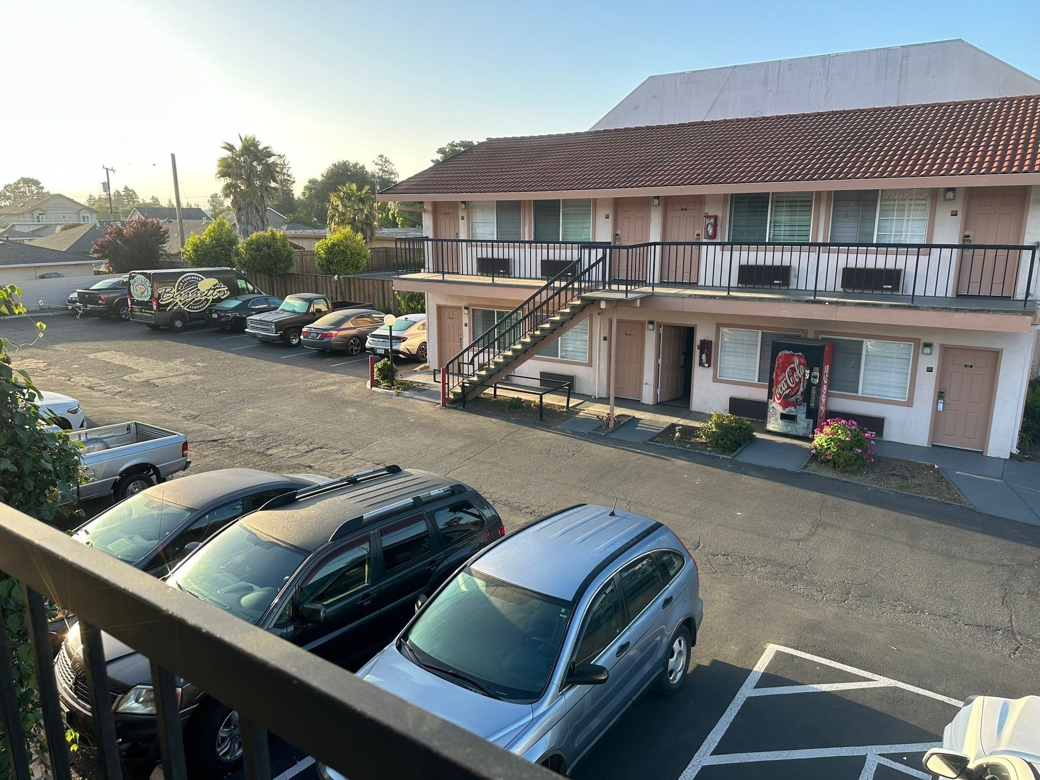 Un motel a due piani con un parcheggio.