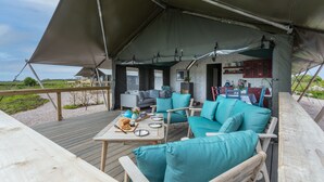 An outdoor seating area with a wooden table, chairs, and a sofa under a large canopy. - Connemara Stone Barn on Wild Atlantic Way, walk to beach, near Aran Island Ferry (Inverin)
