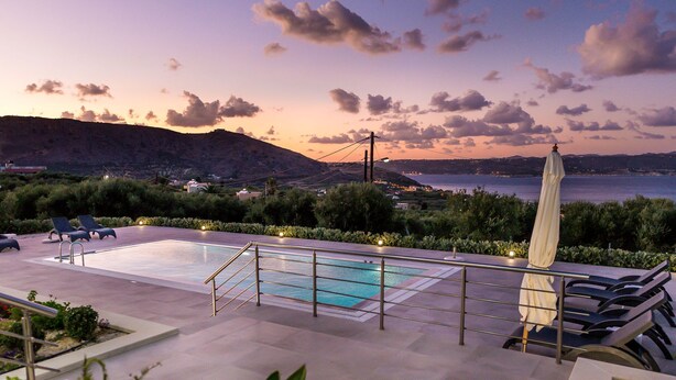 A swimming pool with lounge chairs and an umbrella, overlooking a coastal landscape with hills and a body of water. - Modern and Stylish Villa with Private Pool & Spectacular Views to the Aegean Sea (Chania)