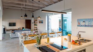 A modern open-plan living space with a kitchen, dining area, and seating area. - Modern and Stylish Villa with Private Pool & Spectacular Views to the Aegean Sea (Chania)