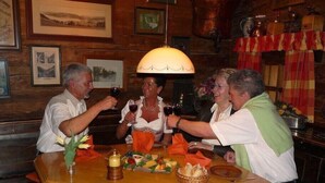 A group of people seated around a wooden table in a warmly lit room with wooden walls and framed pictures. - Lovely, quiet 4-star apartment for two - close to village and lake - Wi-Fi (Titisee-Neustadt)